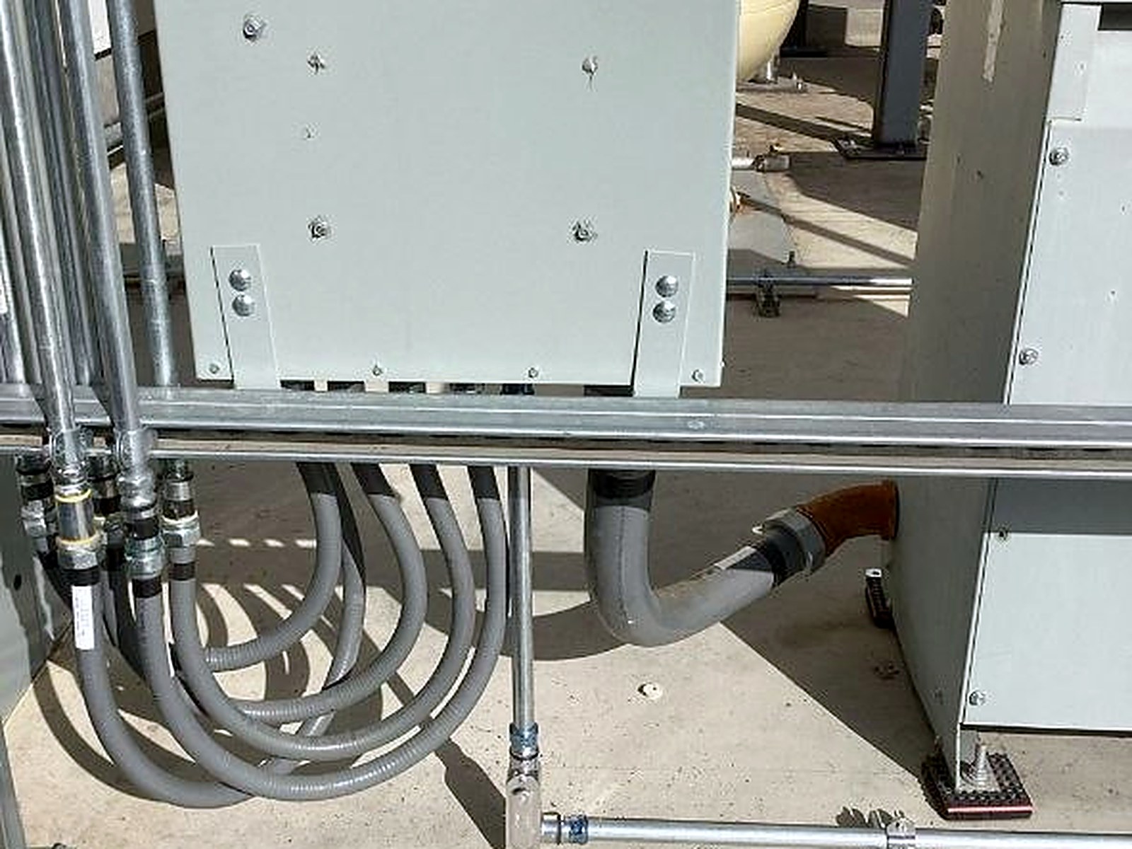 Exterior electrical equipment with multiple conduits routed into a weatherproof enclosure